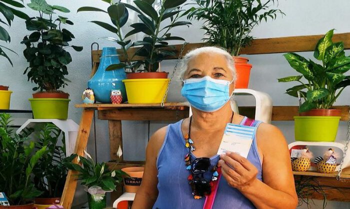 Una clienta posa con la tarjeta de participación.