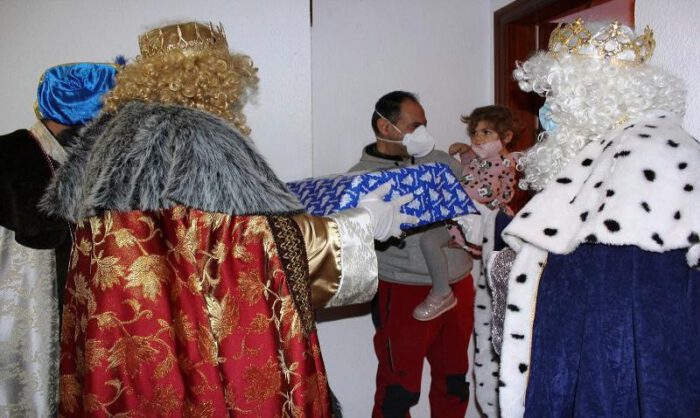 Los Reyes repartiendo regalos en un domicilio.