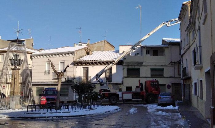 Los bomberos retirando nieve helada de un edificio.