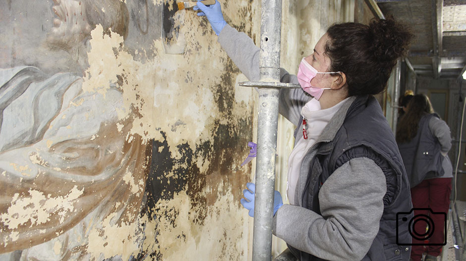 El equipo de Artyco trabaja en la restauración de las pinturas de la nave de la iglesia.