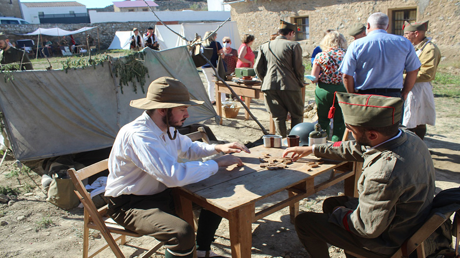 Dos de los recreacionistas interpretando el papel de milicianos jugando al dominó.