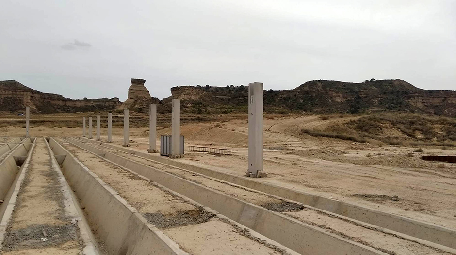 En primer plano, las obras de construcción de la explotación. Al fondo, el tozal de la Cobeta.