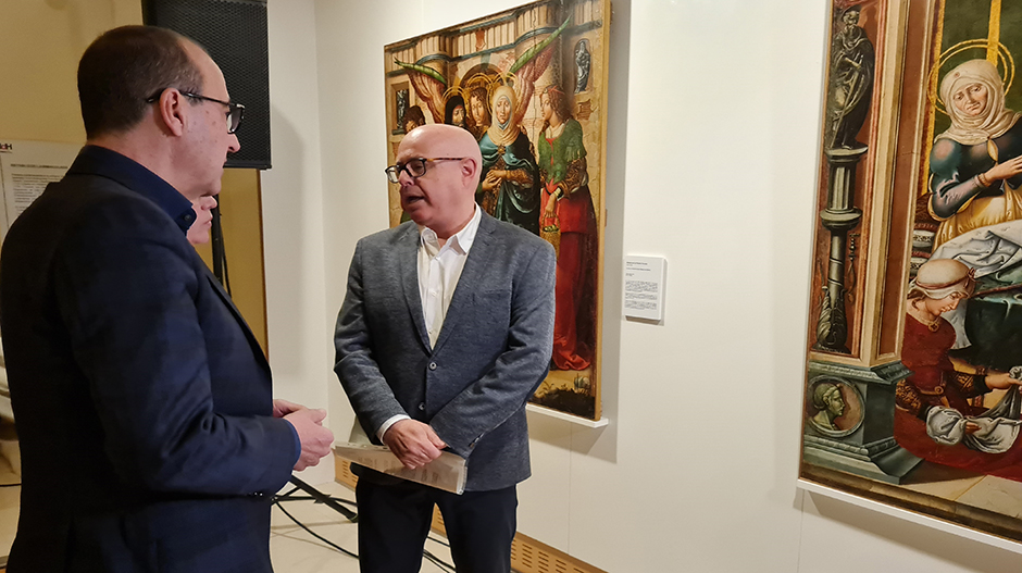 En primer plano, Felipe Faci observando las tablas de Sijena que exhibe el Museo de Huesca.