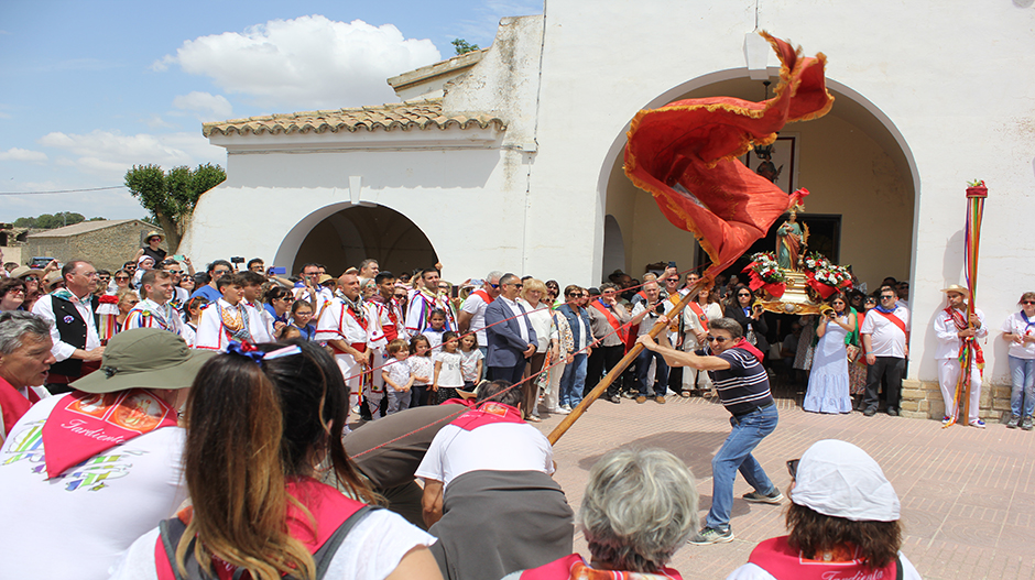 La Bandera inclinándose frente a la imagen de Santa Quiteria en la entrada a la iglesia parroquial.