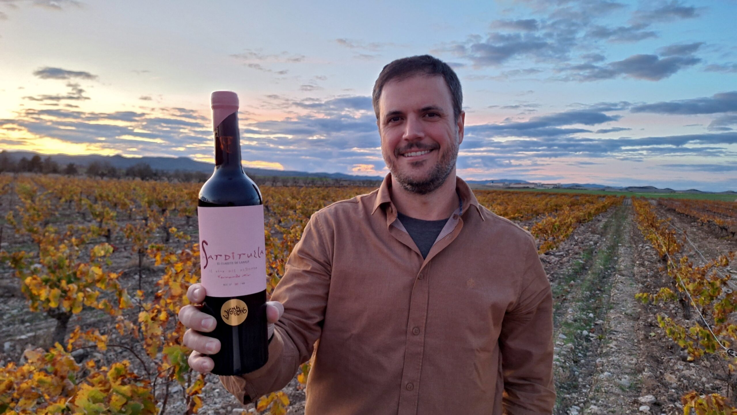 Fernando Mir, entre sus viñedos y con una de las botellas de su nuevo clarete, La Sardiruela.