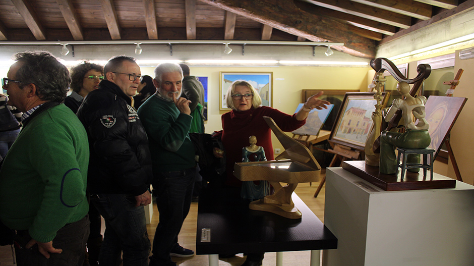 Un grupo de visitantes admirando dos de las figuras en madera aportadas por Miguel Ángel Almerge.