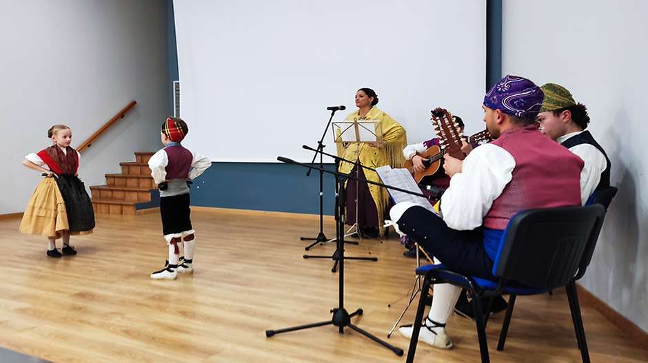 Al fondo, con mantón amarillo, Elena Casaña, junto a la rondalla Ecos de la Sierra durante la entrega de premios del certamen de relatos cortos Tierra de Monegros celebrada en La Almolda.