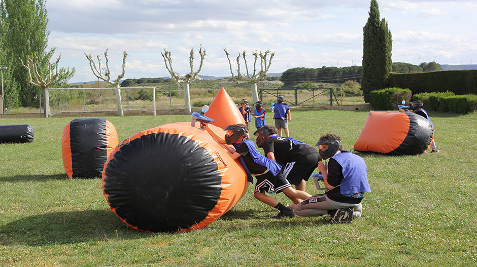 Imagen de un grupo de niños y jóvenes disfrutando del paintball de hidrogel.